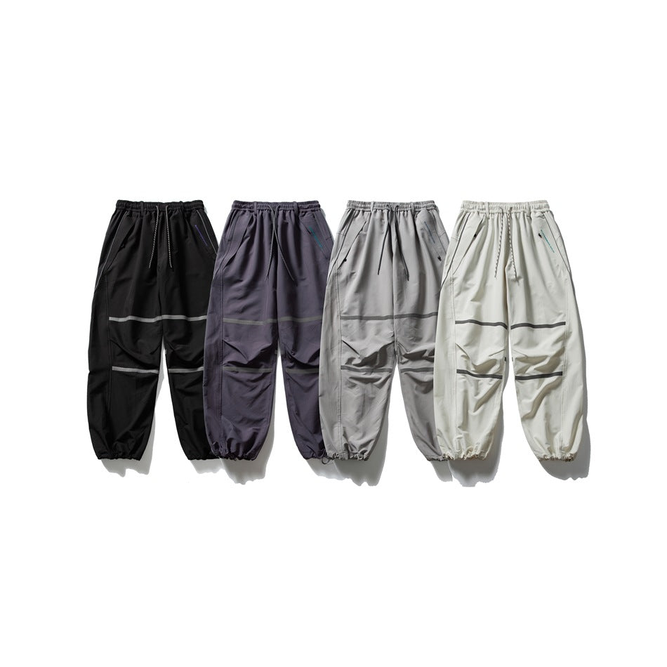 Four pairs of loose drawstring pants shown side by side in black, dark purple, gray, and off-white.