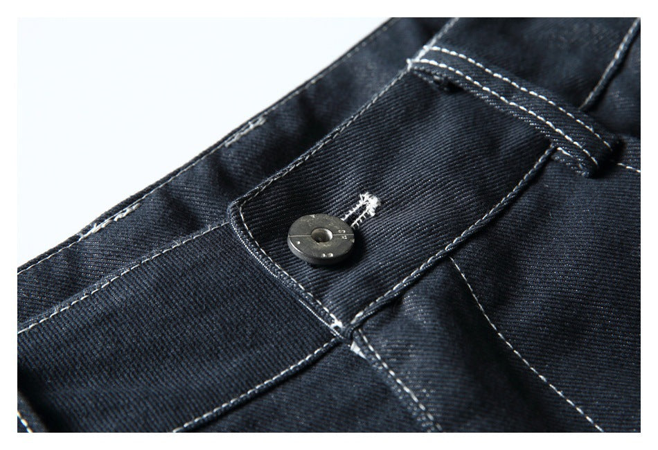 Close-up of a dark trouser waistband button, buttonhole, and belt loop with contrast stitching.