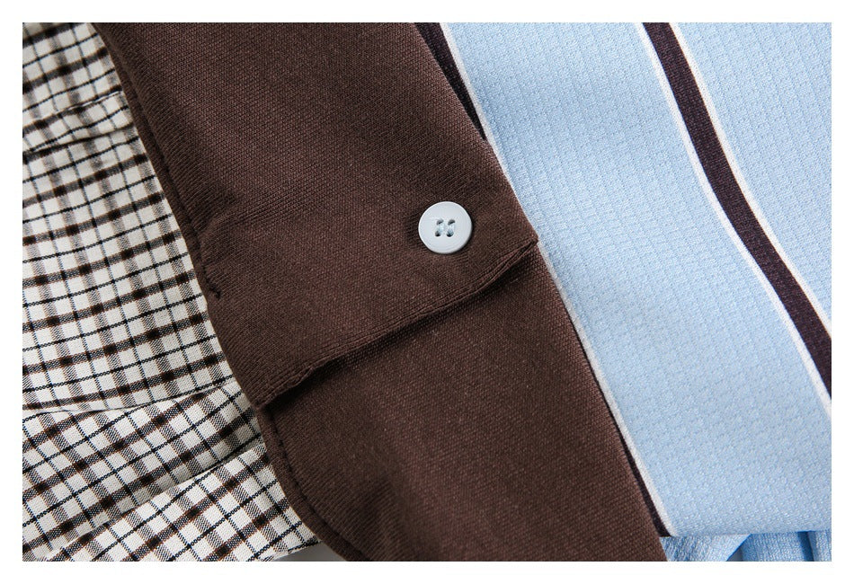 Close-up of a white button on a solid brown cuff beside blue striped and checked fabrics.