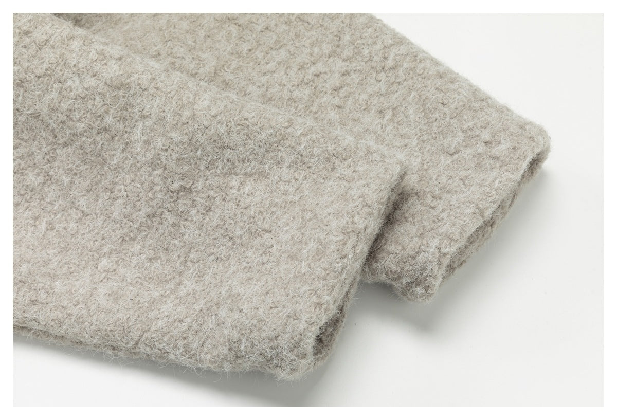 Close-up of a folded edge on a light beige garment with a fuzzy texture.