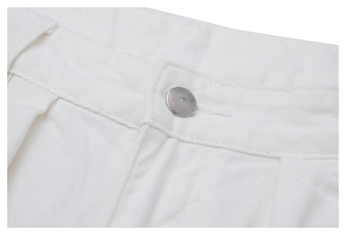 Close-up of white jeans showing a silver waist button, waistband, and stitching.