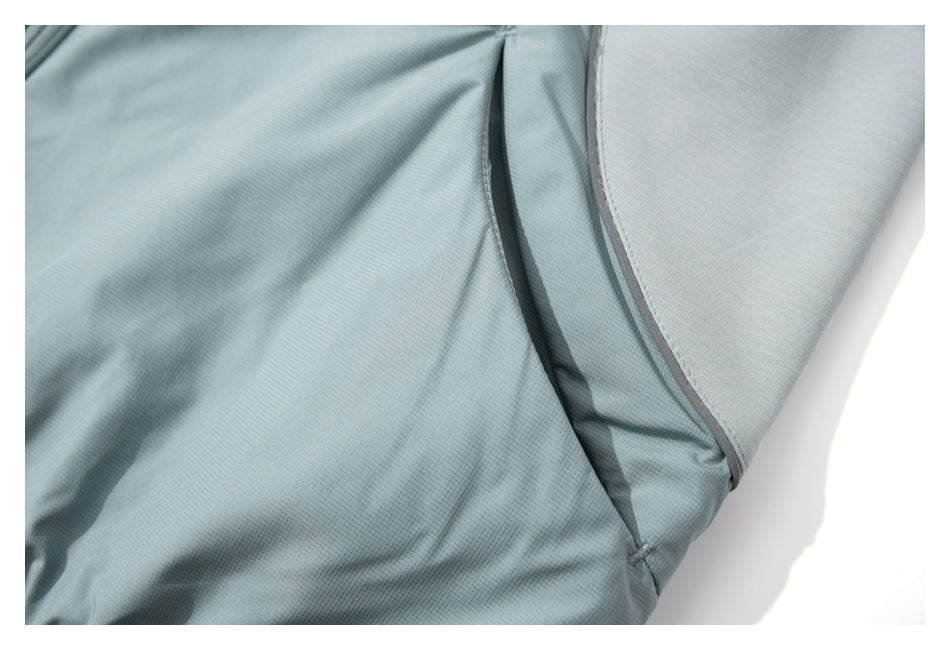 Close-up of pale blue-gray garment fabric and curved seam with contrasting gray trim.