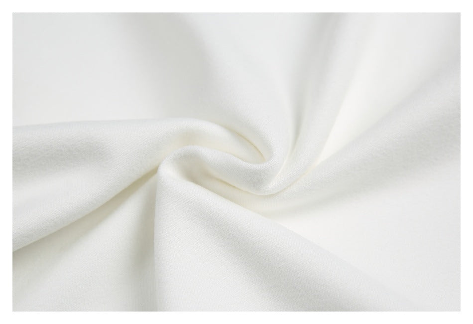 Close-up of soft-looking white fabric gathered into folds, showing its surface texture.