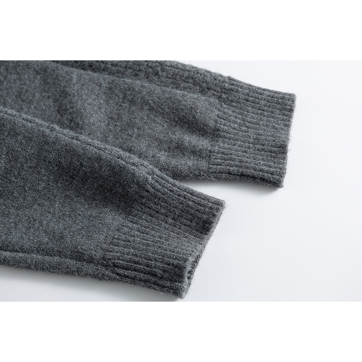 Close-up of two ribbed cuffs on a charcoal gray knit garment.