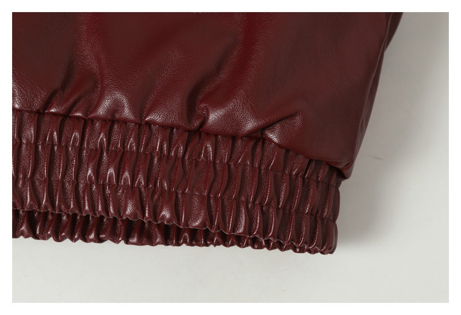 Close-up of a burgundy jacket's gathered elastic hem.