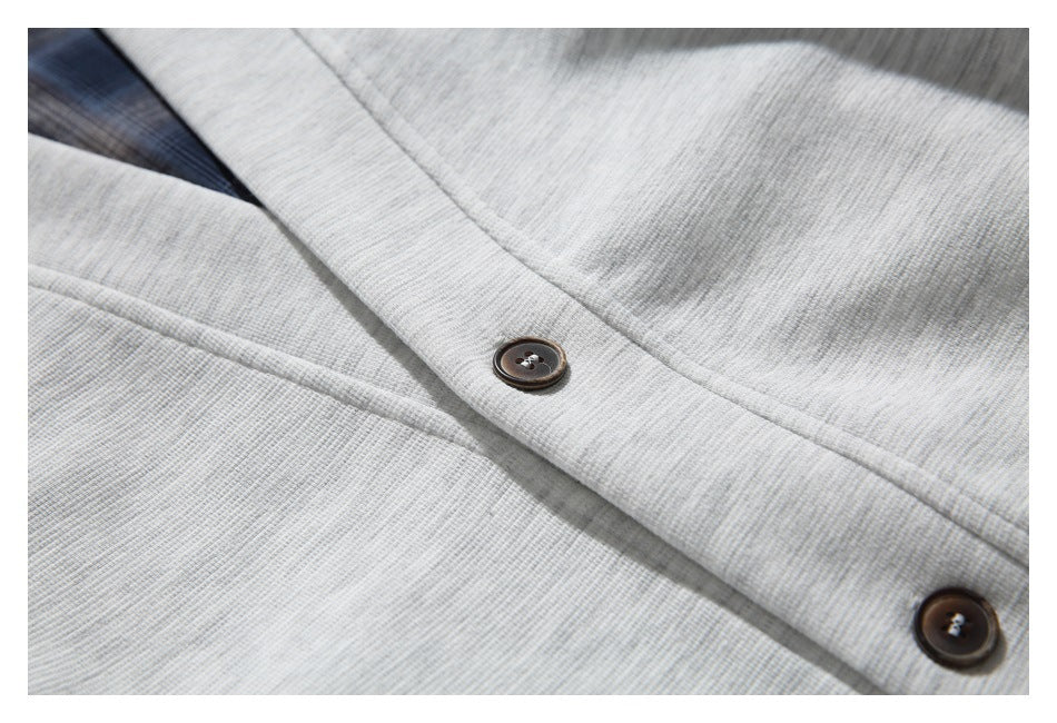 Close-up of the light gray cardigan's textured fabric and dark buttons along the front placket.