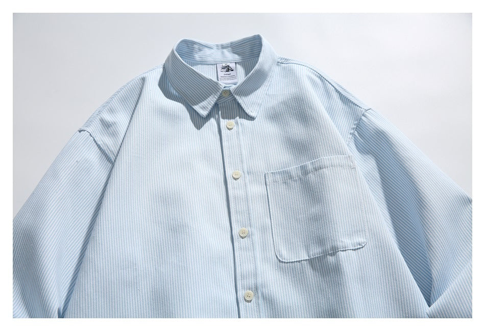 Front view of a pale blue and white striped long-sleeved button-up shirt with a pointed collar and chest pocket.