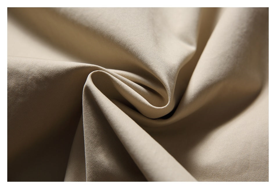 Close-up of beige fabric draped into soft folds, showing its surface texture.