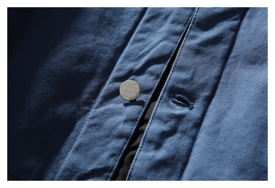 Close-up of a dark blue button placket with a pale round button and buttonhole.