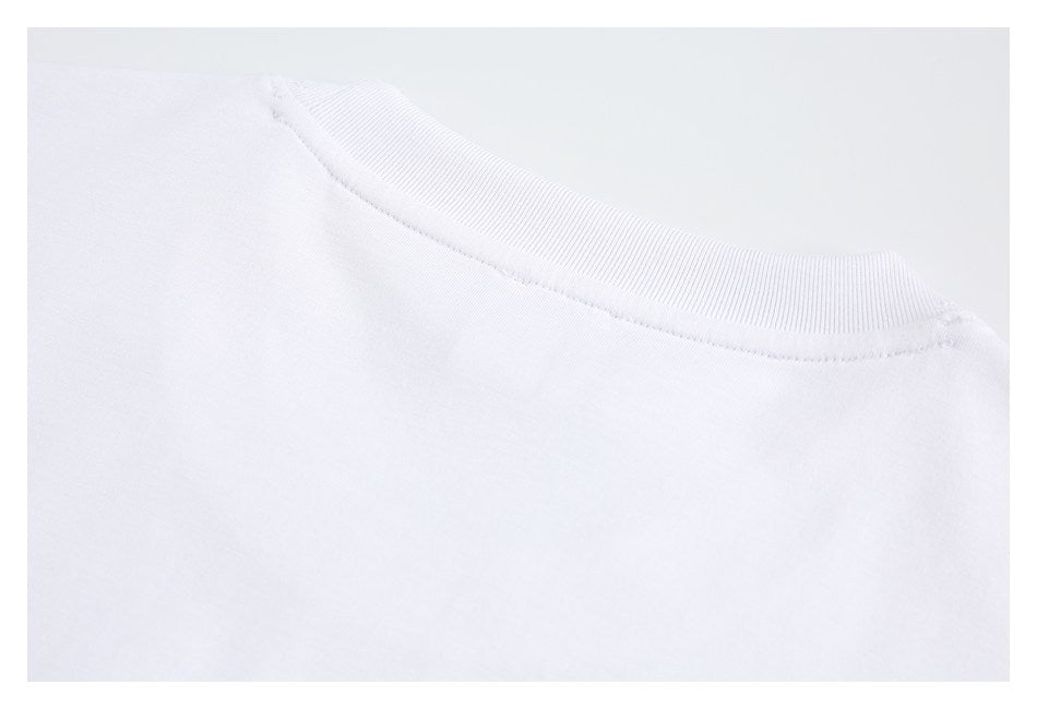 Close-up of the ribbed crew neckline and shoulder seam of a white garment.