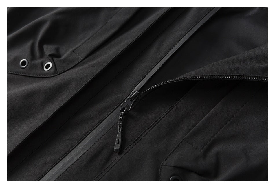 Close-up of a black jacket showing a front zipper, pull cord, and metal eyelets.