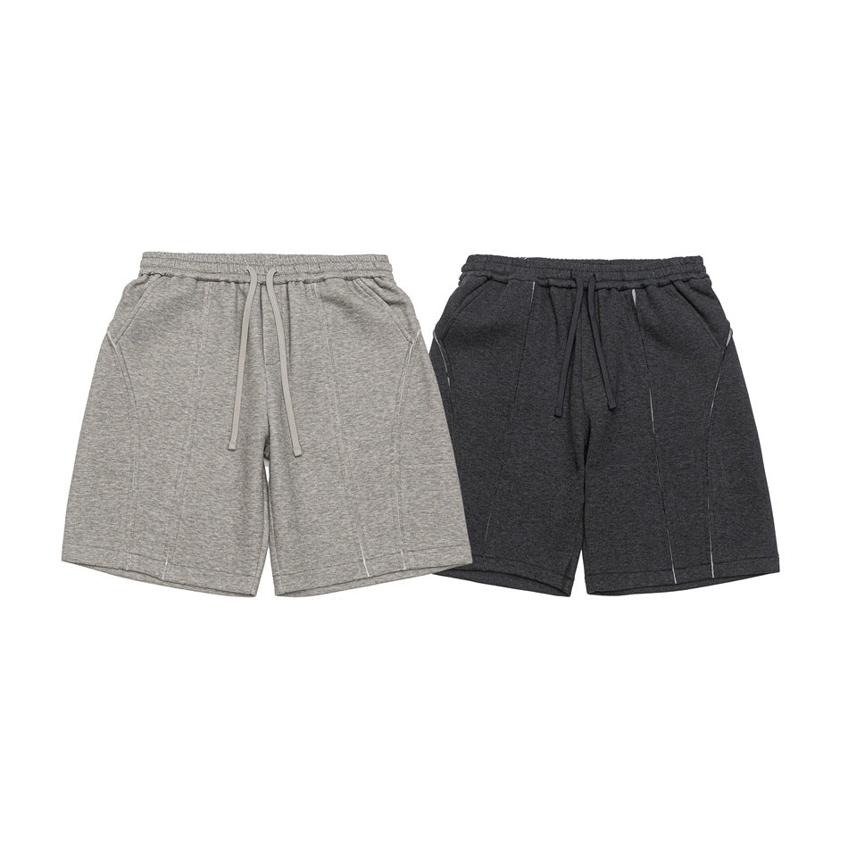 Front view of two pairs of casual shorts in light gray and charcoal, both with elastic waists and drawstrings.