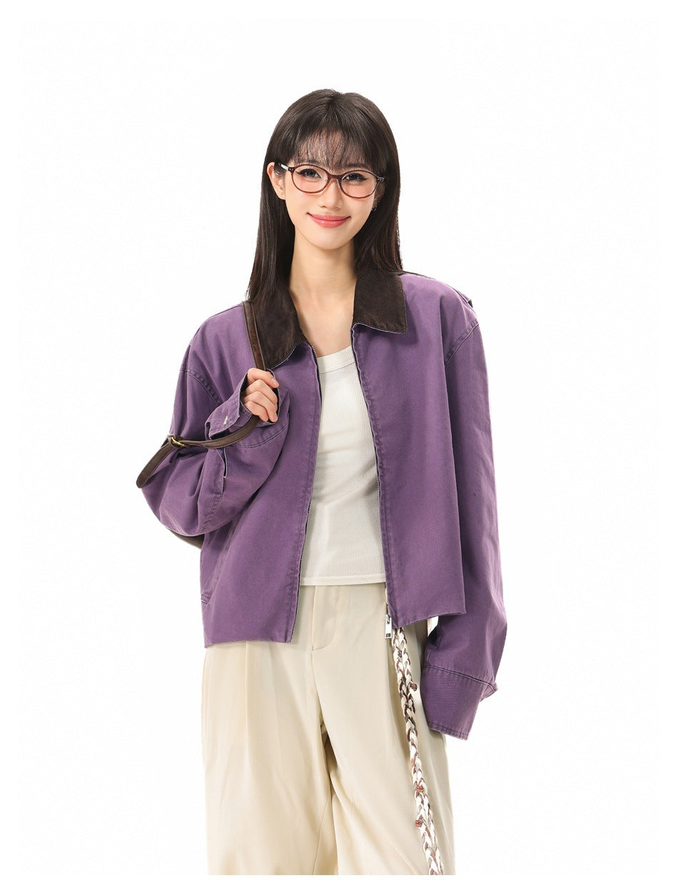 Closer front view of a model wearing an open purple jacket with a dark collar over a white top.