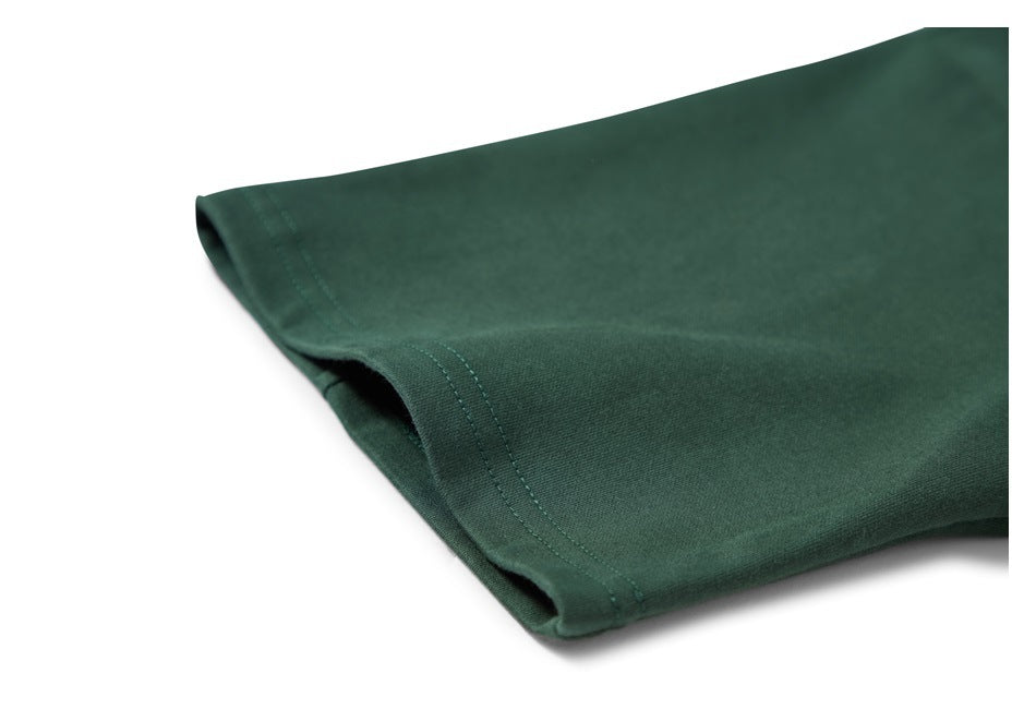 Close-up of the dark green T-shirt's short sleeve hem and stitching.