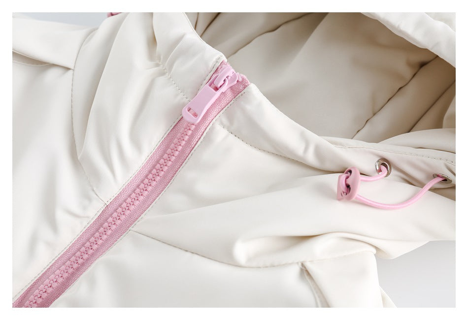 Close-up of the ivory jacket's pink zipper, hood lining, and adjustable drawcord.