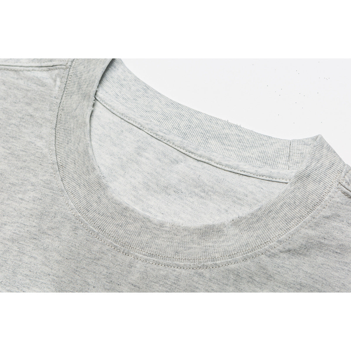 Close-up of the ribbed crew neckline and stitching on a light gray T-shirt.