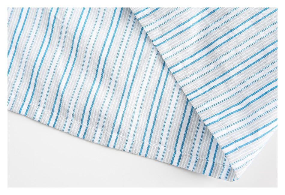 Close-up of the stitched hem on a white shirt with blue and gray stripes.