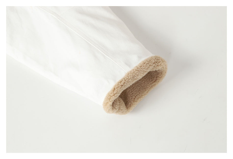 Close-up of a white garment sleeve with a beige plush lining inside the cuff.