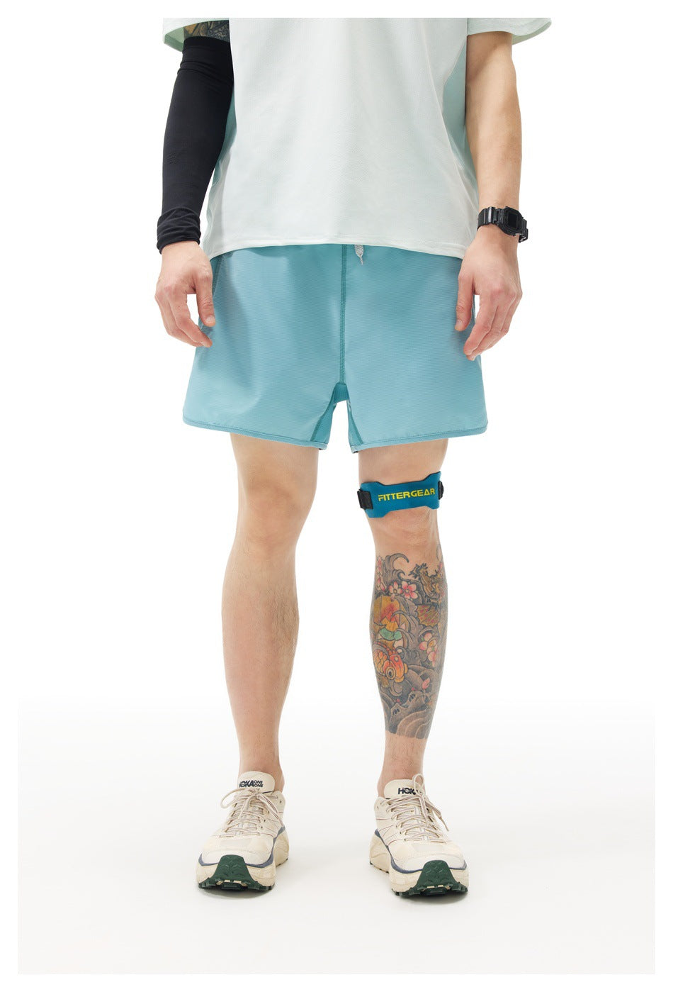 Front view of a model wearing light blue running shorts with a white shirt against a plain background.
