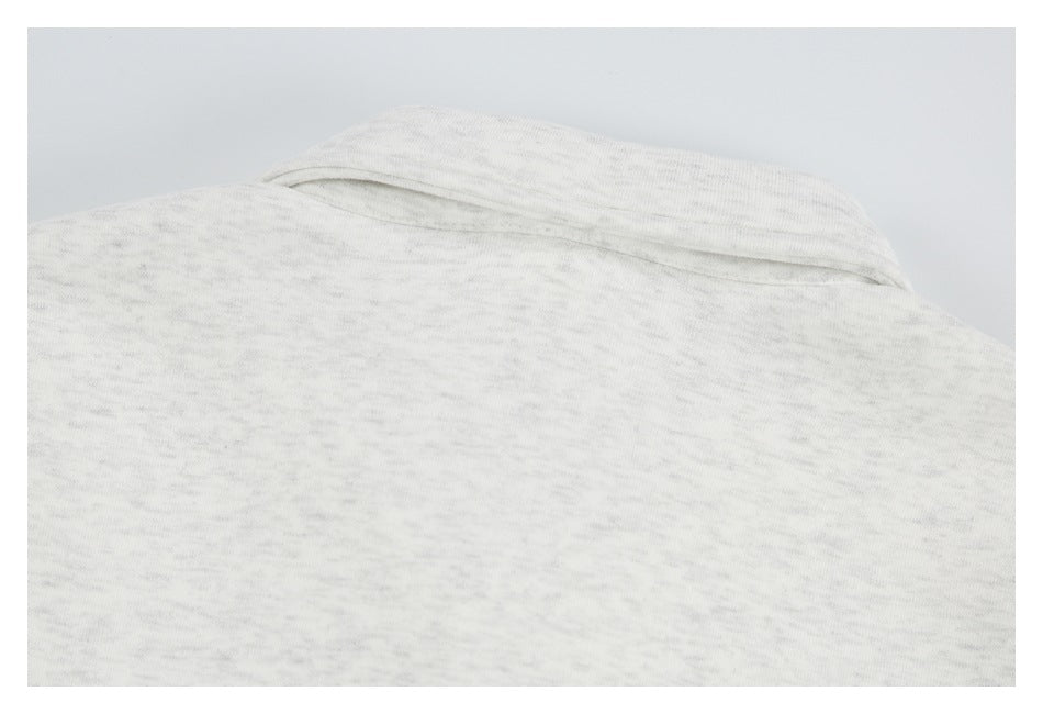 Close-up of the back neckline and collar seam on a light heather-gray garment.