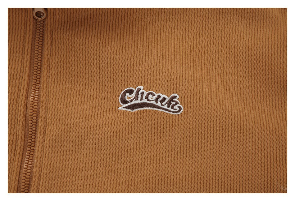 Tan ribbed garment close-up with a brown zipper and small embroidered white script logo.