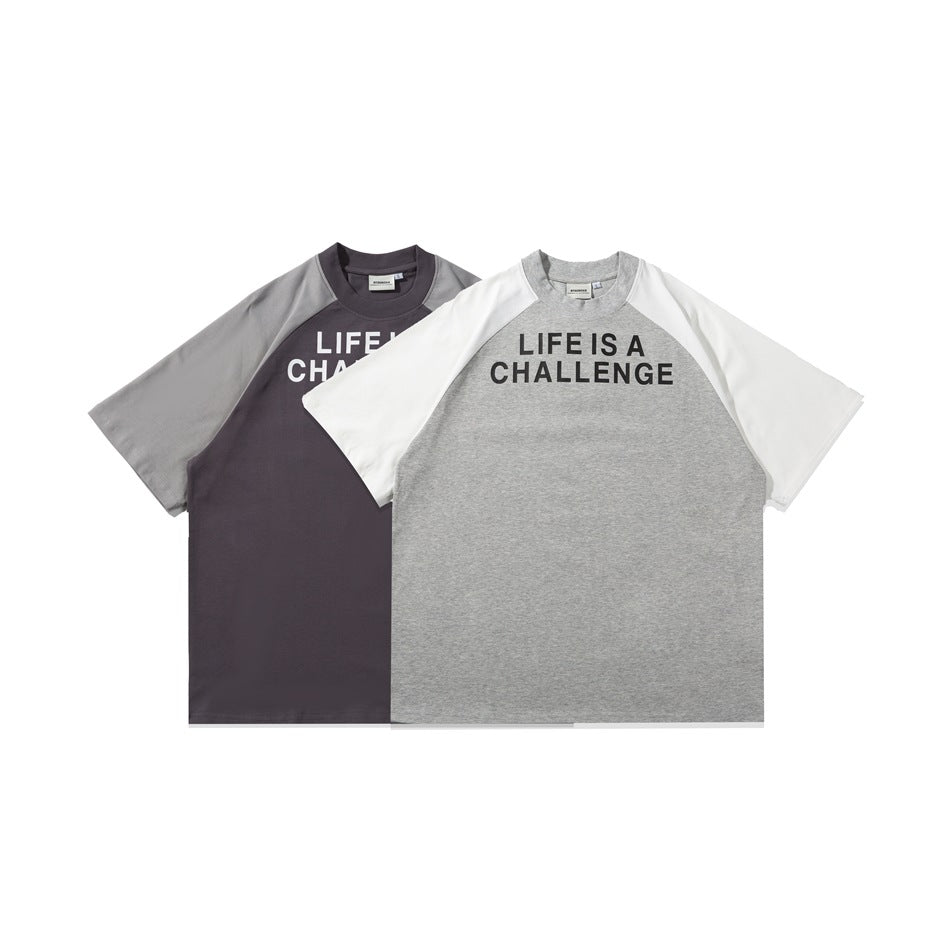 Two raglan T-shirts displayed flat: charcoal with gray sleeves and gray with white sleeves, both printed “LIFE IS A