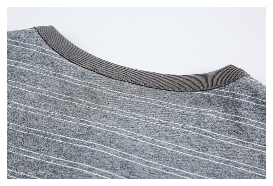Close-up of a dark ribbed crew neckline on gray heathered fabric with thin white stripes.
