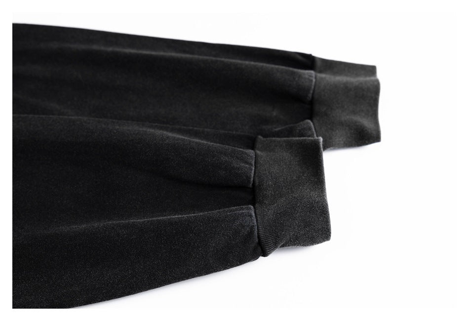 Close-up of black sleeves with wide ribbed cuffs on a white background.