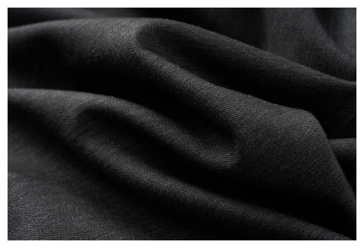 Macro view of black fabric draped in rounded folds, showing its fine textured surface.
