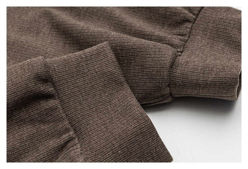 Close-up of the brown textured garment's folded sleeve and cuff.