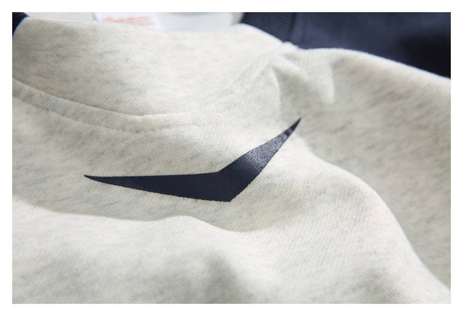 Close-up of a dark navy angular graphic printed on the light gray sweatshirt chest.