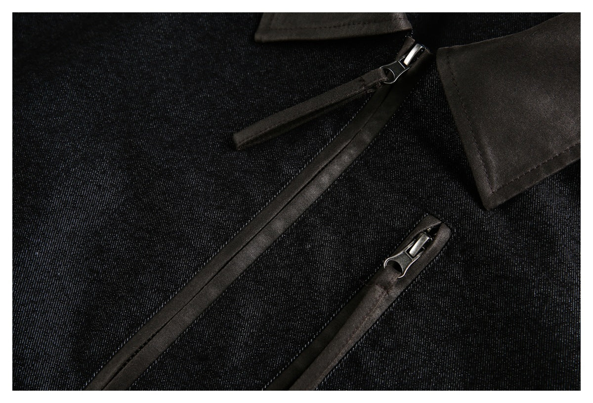 Close-up of the jacket's front zipper, chest pocket zipper and dark textured fabric.