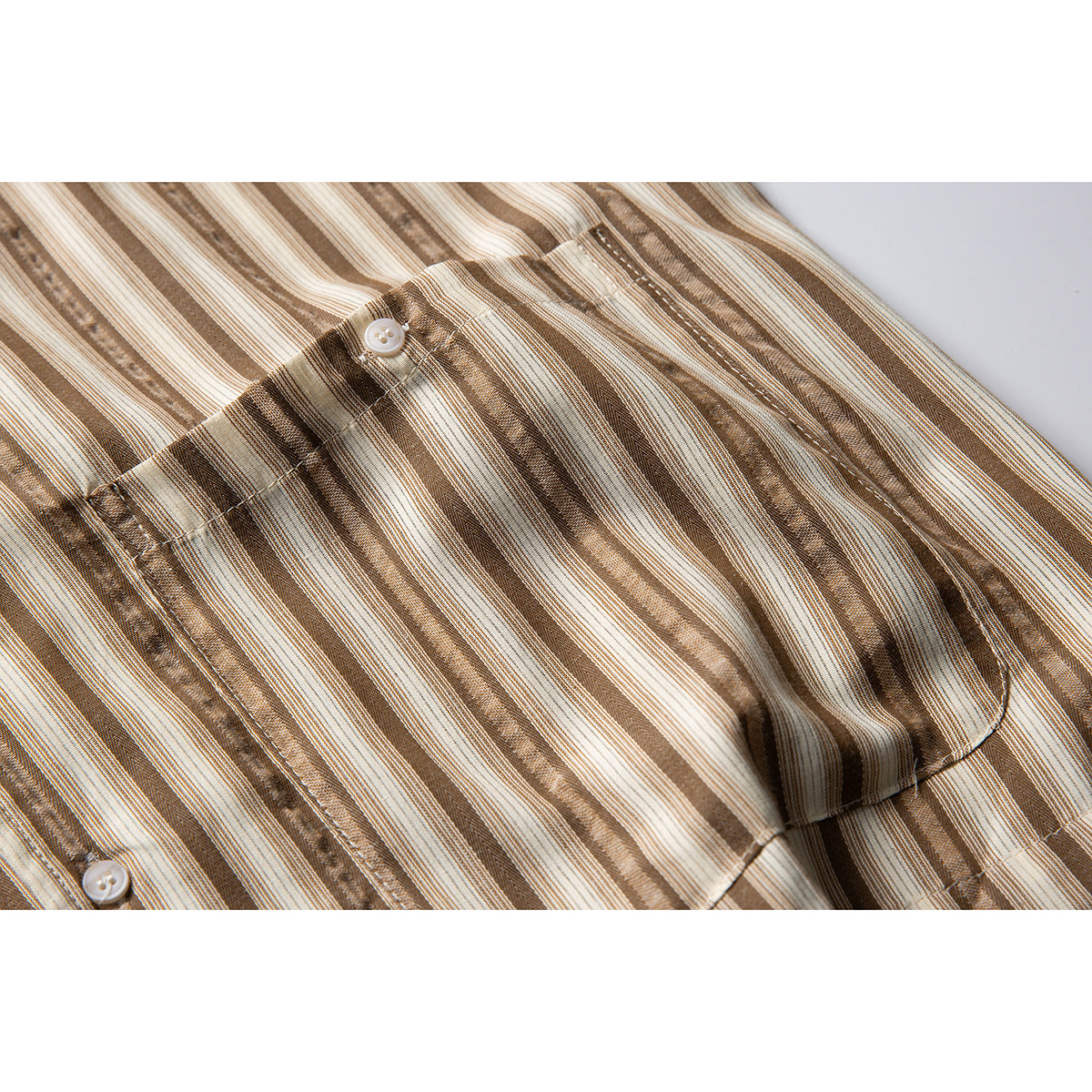 Close-up of a cream and brown striped shirt with a buttoned chest pocket.