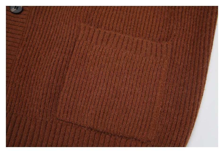 Close-up of a patch pocket on the ribbed rust-brown cardigan.