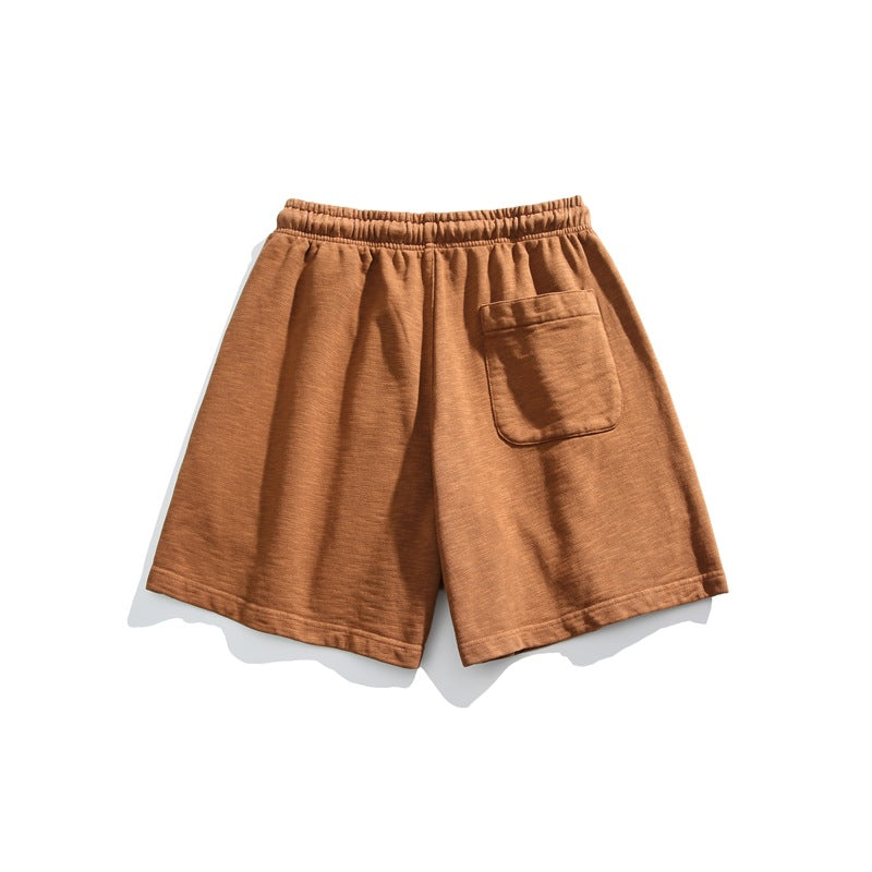 Rust brown shorts shown from the back, with an elastic waistband and a single patch pocket.