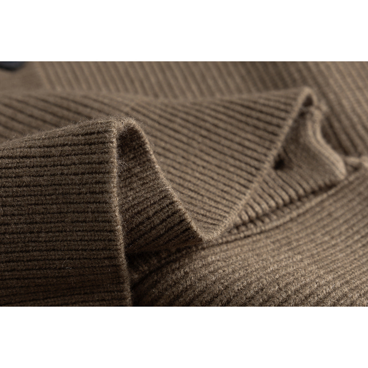 Macro view of the taupe-brown cardigan's ribbed knit fabric and folded edge.