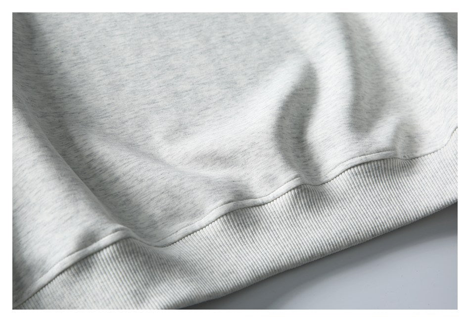 Close-up of the light gray heathered garment's ribbed bottom hem.