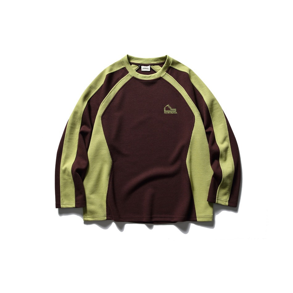Front view of a burgundy long-sleeve top with lime-green raglan panels and a small chest emblem.