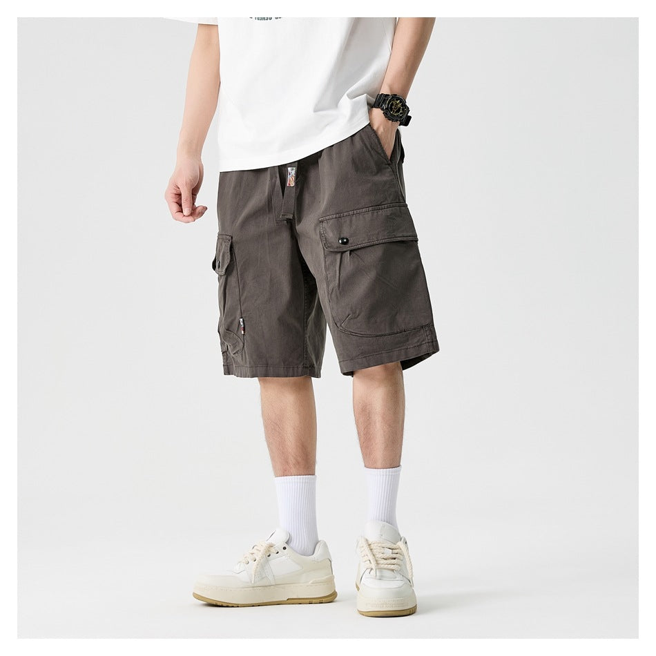 Model wearing charcoal gray cargo shorts with a drawstring waist and large flap pockets.
