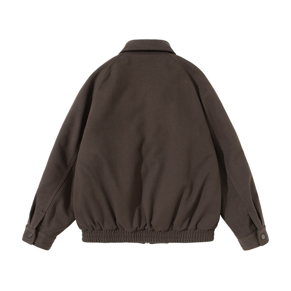 Back view of a dark brown jacket with raglan sleeves, buttoned cuffs, and a gathered elastic hem.