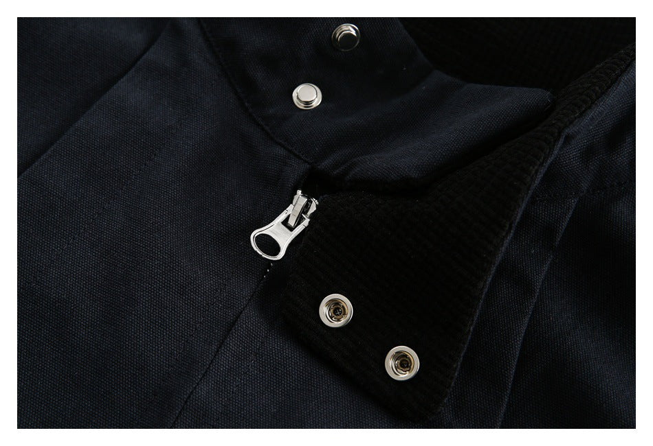 Close-up of a black jacket's zipper, snap fasteners, and textured inner collar lining.