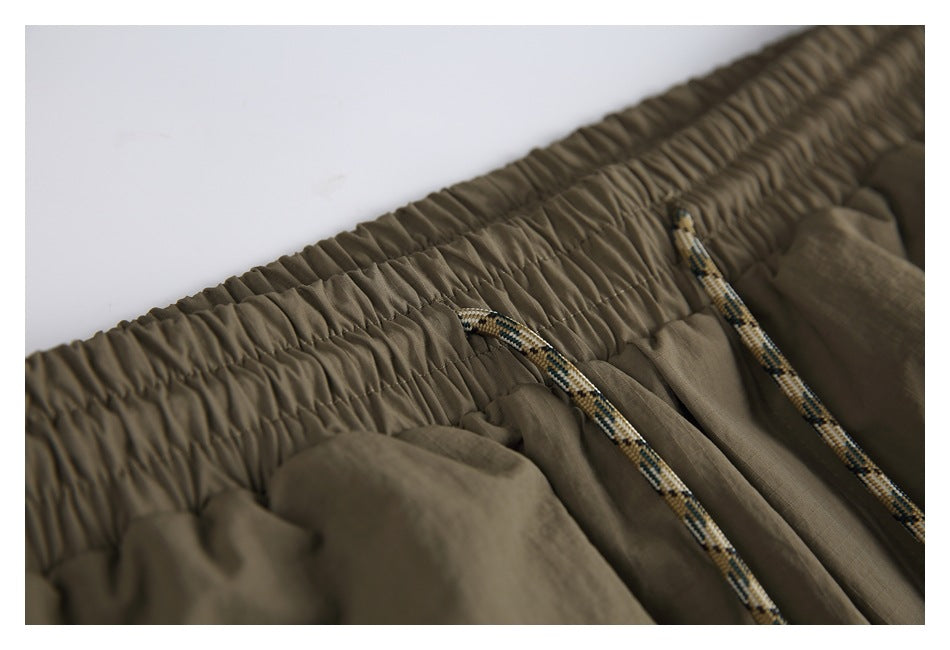 Close-up of the pants' gathered elastic waistband and patterned drawcords.
