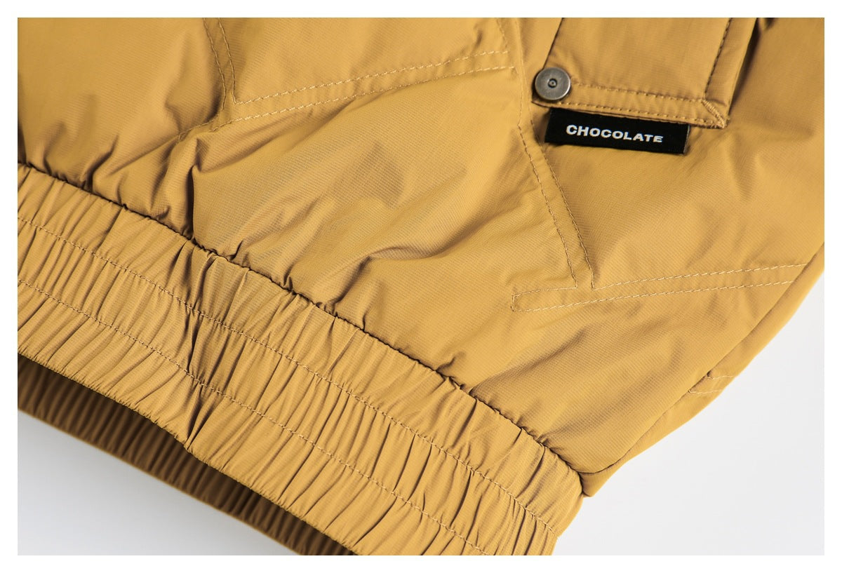 Close-up of a mustard garment's elasticated hem and a black CHOCOLATE label.