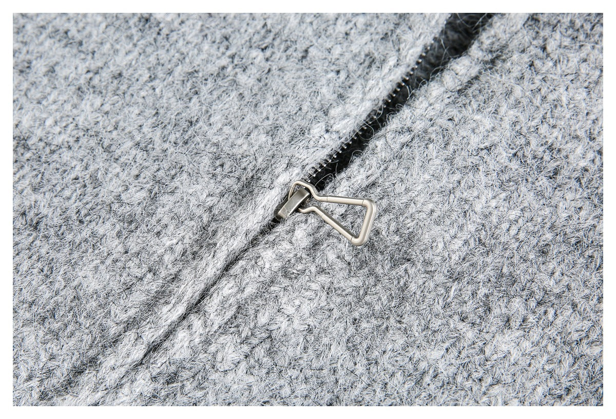 Close-up of gray marled knit fabric with a dark zipper and metal pull.