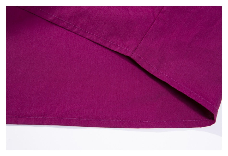 Close-up of a deep magenta garment hem and overlapping stitched seam.