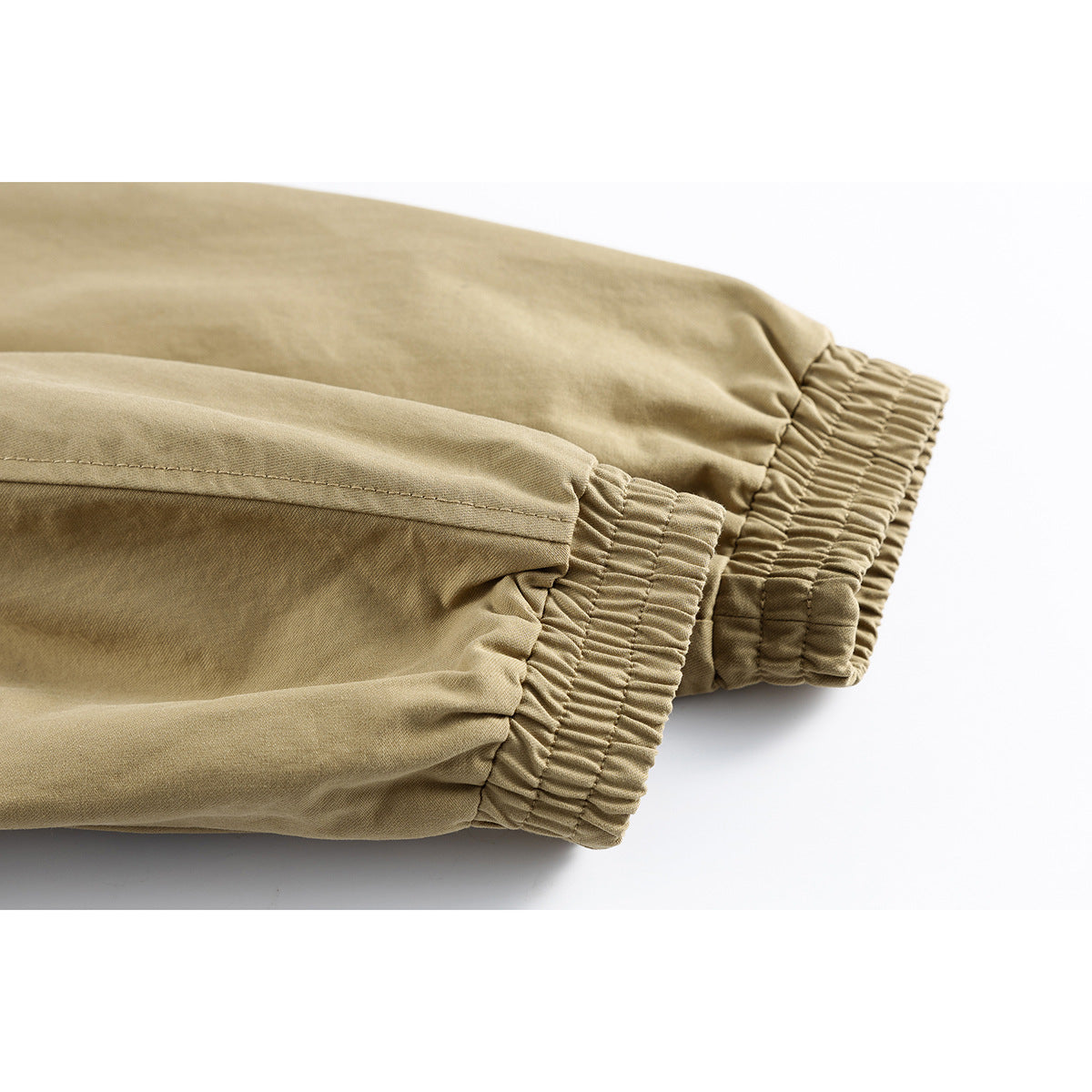 Close-up of the khaki jacket's gathered elastic cuffs and sleeve seams.