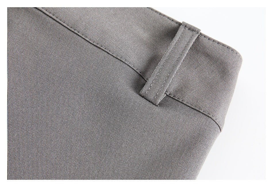 Close-up of gray trouser waistband with a belt loop and visible stitching.