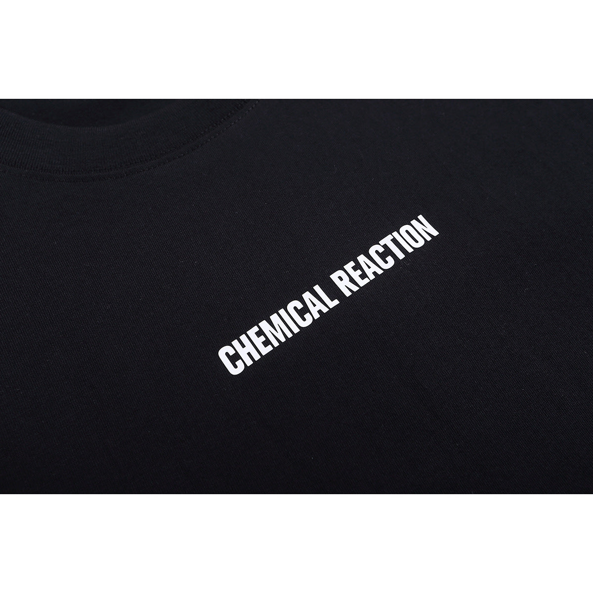Close-up of a black T-shirt with diagonal white “Chemical Reaction” lettering on the chest.
