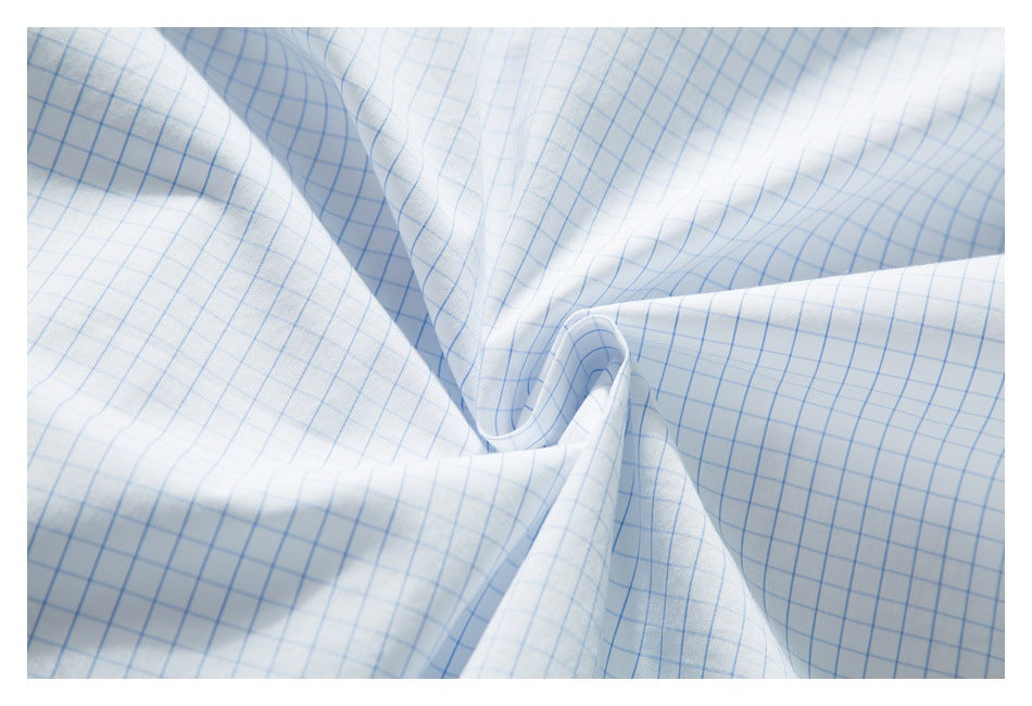 Close-up of the draped white shirt fabric with a light blue grid pattern.