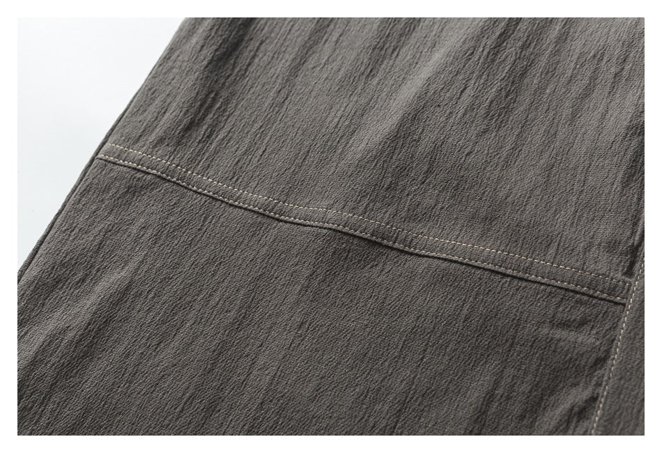 Close-up of the charcoal shirt fabric and a curved seam with light contrast topstitching.